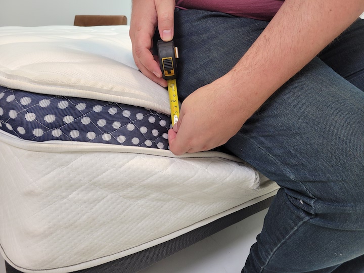 A man sits on the edge of the WinkBed mattress