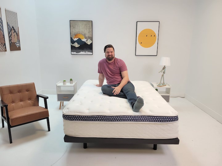 a man sits on top of the WinkBed mattress