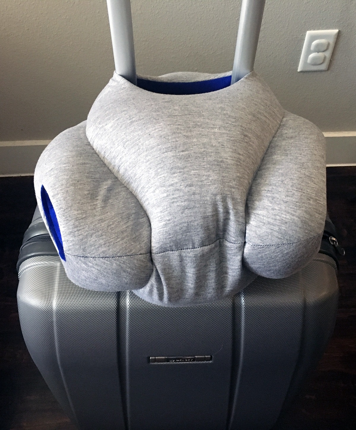 Ostrichpillow looped around suitcase handle