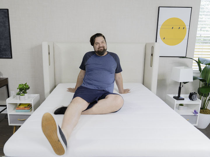 a man sits on top of the Helix Plus mattress