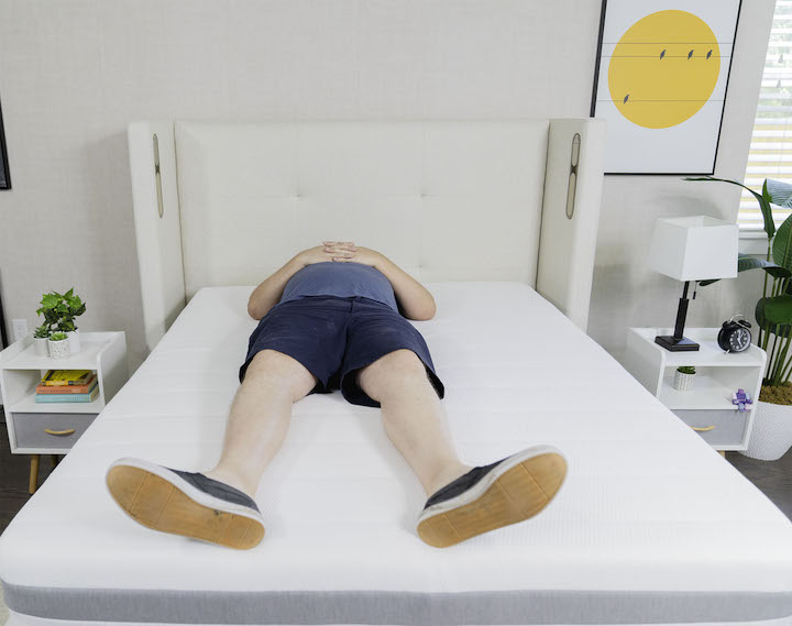 a man sleeps on his back on the Helix Plus mattress