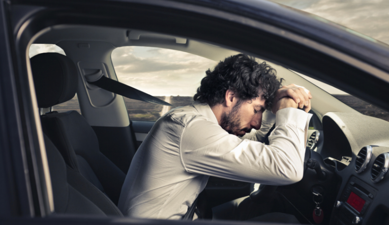 Man falling asleep at wheel of car