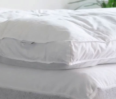 An image of the Parachute Down Topper's corner as it rests on a bed.