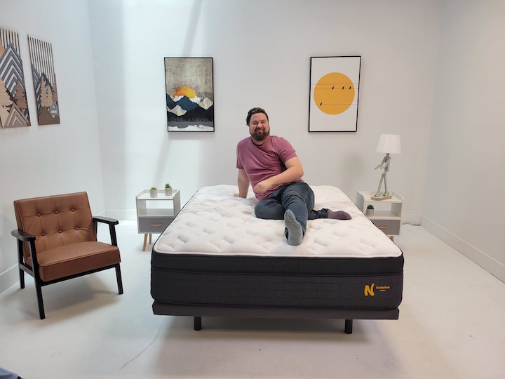 a man sits on top of the Nolah Evolution mattress