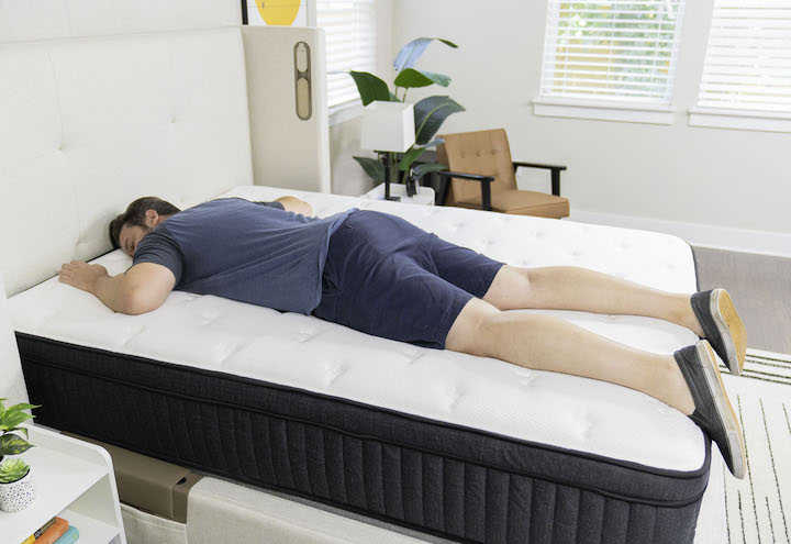 a man sleeps on his stomach on the Titan Plus mattress