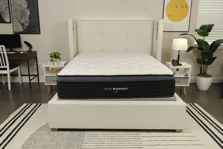 the Helix Midnight Luxe sits on a bed frame in a bedroom