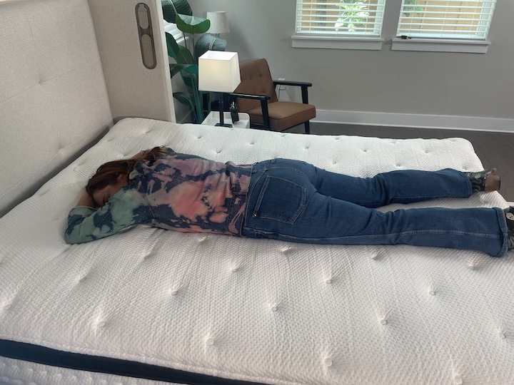a woman sleeps on her stomach on the PlushBeds Signature Bliss mattress