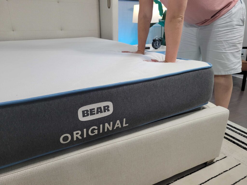 Man pushing down on surface of the Bear Original mattress with two hands