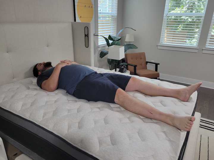 A man rests on his back on the Helix Plus Luxe
