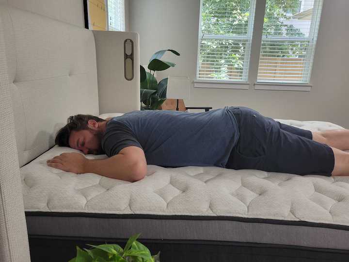 a man sleeps on his stomach on the Helix Plus Luxe
