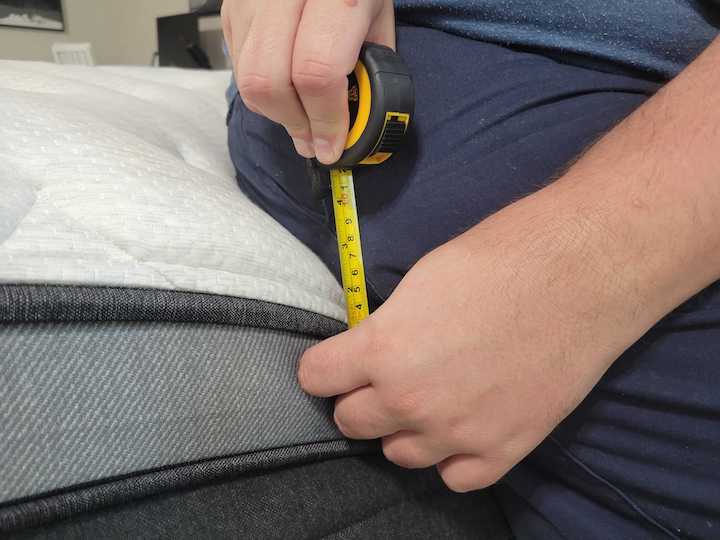 a man measures the Helix Plus Luxe's edge support