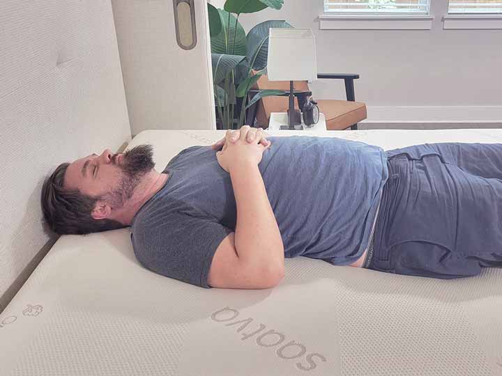 A man rests on his back while on top of the Saatva Contour5 mattress.