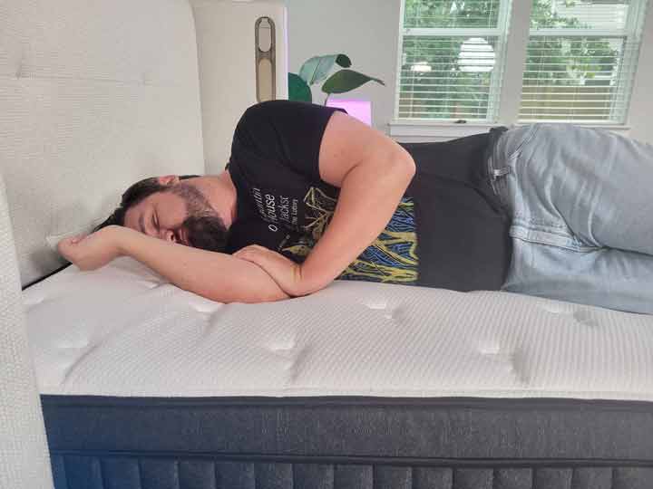 An image of a man sleeping on his side while on top of the Titan Plus Luxe mattress