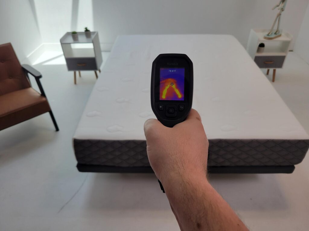 man measuring the temperature of the puffy cloud mattress after it has been rested on