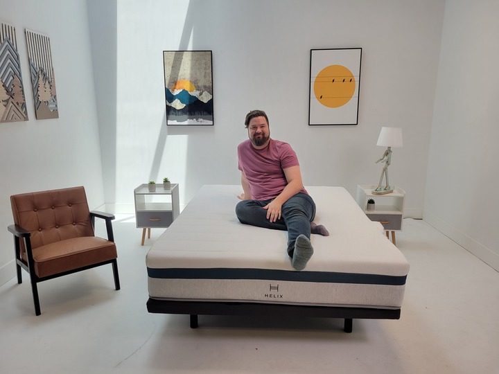 A man sits on top of the Helix Twilight mattress