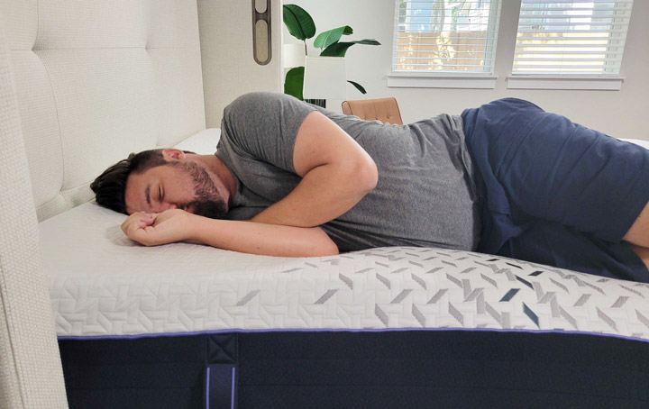 A man sleeps on his side on the Nectar Luxe Hybrid