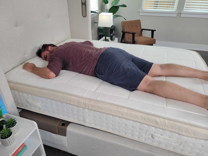 A man sleeps on his stomach on the Awara Natural Luxury Hybrid mattress.