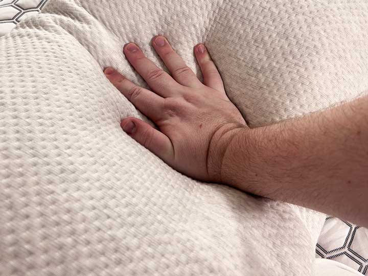 An image of a hand pressing into the Bear Talalay Latex pillow.